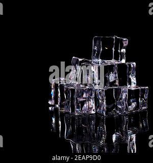 Ice cubes are arranged in a slide, isolated on a black background. Stock Photo