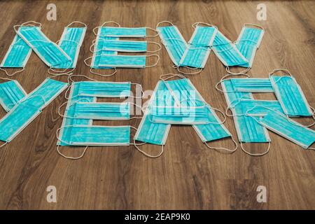 Letters New Year Composed of Blue Medical Masks on a Brown Background Stock Photo
