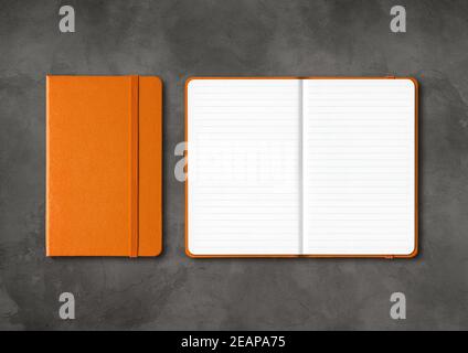 Orange closed and open lined notebooks on dark concrete background Stock Photo