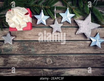Christmas stars on wooden background with fir tree branches Stock Photo