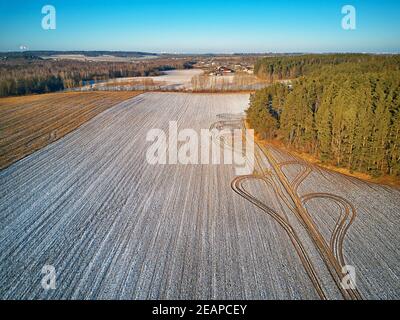 Winter Agricultural field under snow. Aerial scene. December Rural landscape. Stock Photo