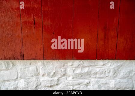 Bright red wood and whitewashed stone exterior wall close up. Stock Photo