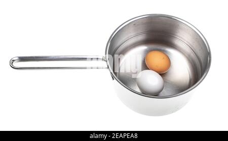 two eggs in saucepan with water isolated Stock Photo