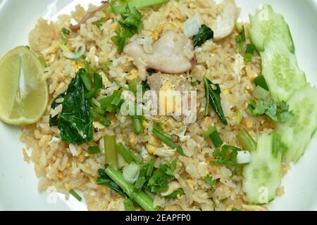 fried rice pork and seafood with slice cucumber and lemon on plate Stock Photo