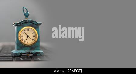 Vintage style miniature clock on grey banner template. Stock Photo
