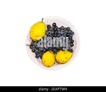 Yellow pear and grapes on the plate Stock Photo