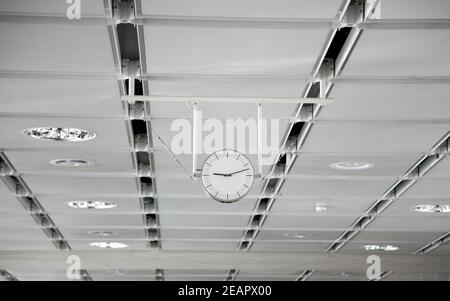 Hanging white clock at the big train station Stock Photo