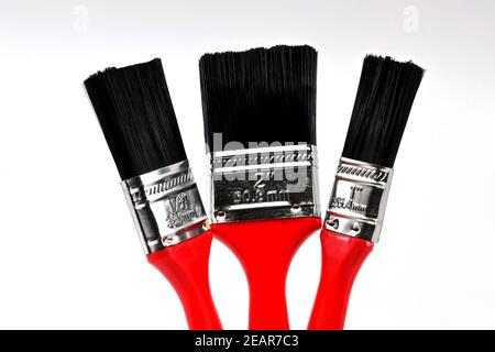 Three paint brushes of different sizes on a plain white background. No people. Copy space. Stock Photo