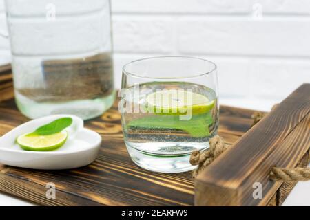 A glass of home made lemonade stands on a wooden tray Stock Photo