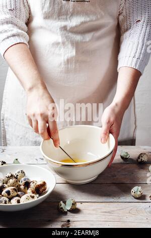Woman whipping quail eggs in bowl, making mayonnaise. Stock Photo