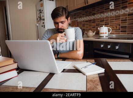 Monday morning again. Dissatisfied freelancer works at home. having sleep deprivation, lazy millennial guy distracted from work feel lazy lack motivat Stock Photo