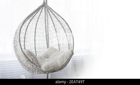 White swing hammock in a modern interior. White background with place for text. Selective focus Stock Photo