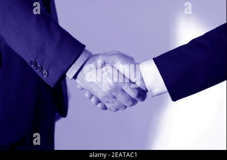 Handshake between two elegant businessmen, monochrome photo Stock Photo