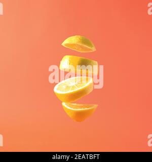 Artistic fresh summer fruit lemon slices floating against a pastel square background Stock Photo