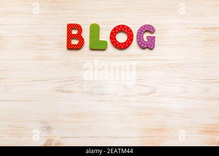 Colorful word BLOG made of colorful wooden letters on vintage white painted wooden board. Copy space. Top view, flat lay Stock Photo