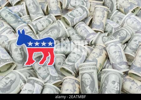 Democrat donkey logo patch badge & US dollar banknotes (training copies). For US political fundraising & Democrat PAC campaign funds, Biden debt pile. Stock Photo
