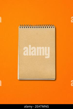 Spiral closed notebook mockup on orange background Stock Photo