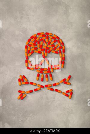Skull made of orange capsule pills. Concrete background Stock Photo