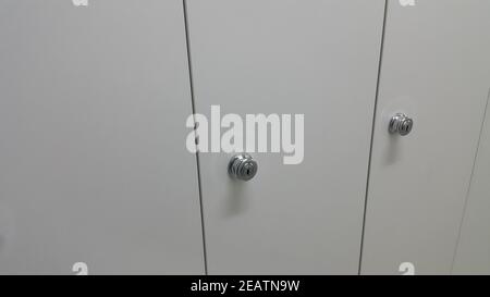 Perspective view of lockers or cupboards in a row with white doors Stock Photo