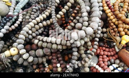 Beautiful wooden prayer beads or rosary placed over fabric background Stock Photo