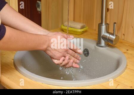 The girl washes her hands under running water in the sink Stock Photo ...