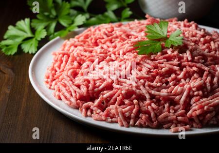 Minced meat served on a round plate on a wooden background Stock Photo