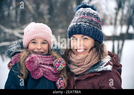 Mother and daughter playing in winter park Stock Photo