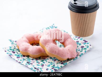 Hot coffee with pink donuts on a marble background Stock Photo