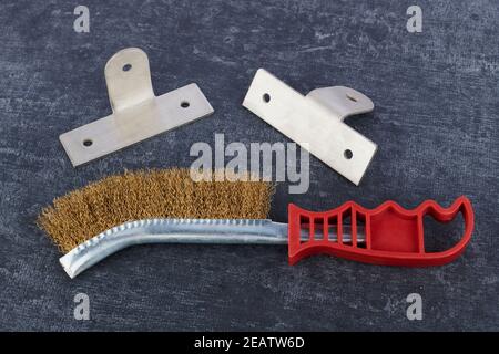 Metal brush for cleaning metal surfaces and aluminum corners on grey background, close up, shallow depth of sharpness Stock Photo