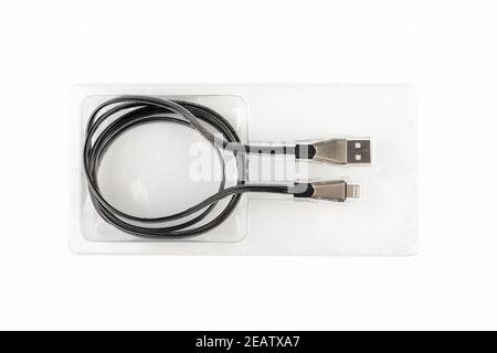 Top view of a data or charging cable with USB connectors in a blister. Close up. Copy space. Stock Photo