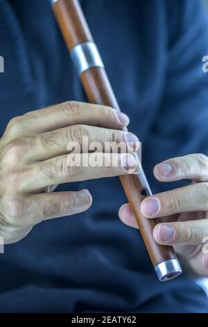 Wooden flute player Stock Photo