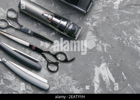 Barber shop equipment on Black background with place for text. Professional hairdressing tools. Comb, scissor, clippers and hair trimmer Stock Photo