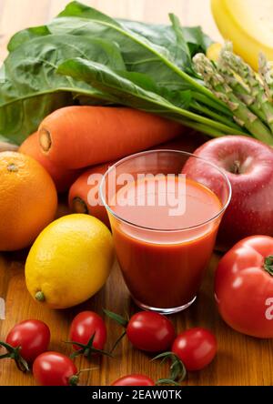 A variety of fruits and vegetables and a glass of vegetable juice Stock Photo