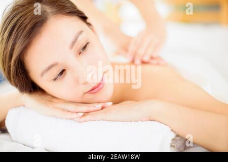 relaxed Young woman enjoy massage in spa salon Stock Photo