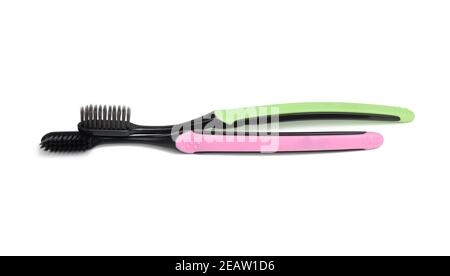 pink and green plastic toothbrushes isolated on white background Stock Photo