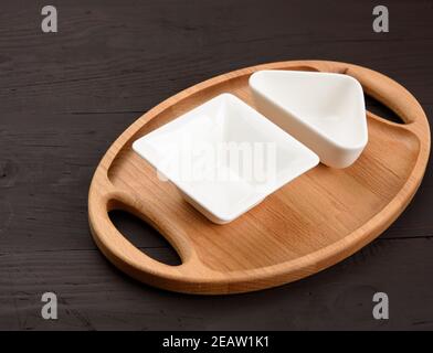 empty white ceramic plates and oval wooden tray board Stock Photo