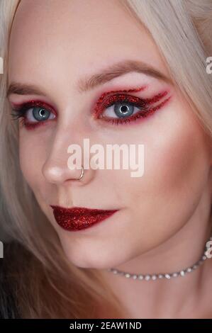 young blond woman with red glitter makeup Stock Photo