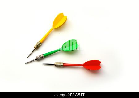 Yellow, green and red darts on a white background, close-up Stock Photo