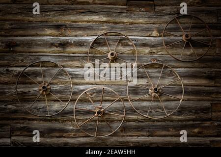 Old metal wheels on a wall Stock Photo