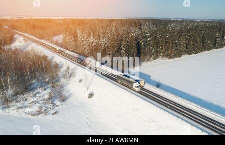 Cargo trucks on motorway in winter landscape  aerial drone view Stock Photo