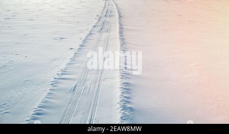 Car traces on snow field aerial above drone view Stock Photo