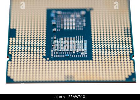 A macro photo of a modern CPU processor under the LGA 1200 socket on a green circuit board, isolated on a white background. Stock Photo