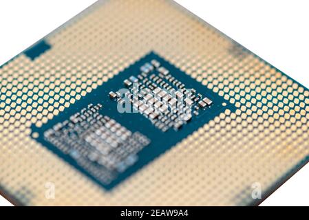 A macro photo of a modern CPU processor under the LGA 1200 socket on a green circuit board, isolated on a white background. Stock Photo