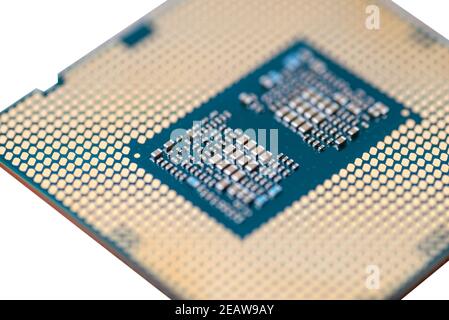 A macro photo of a modern CPU processor under the LGA 1200 socket on a green circuit board, isolated on a white background. Stock Photo
