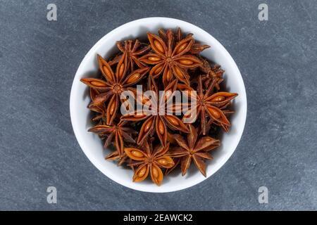 Star anise star-anise Christmas spice herb from above bowl on a slate Stock Photo
