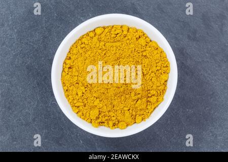 Curry powder spice from above bowl on a slate Stock Photo