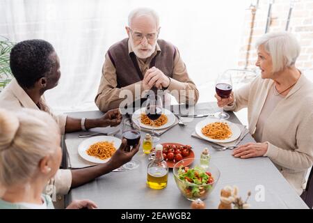 high angle view of multicultural men and women having delicious lunch together Stock Photo