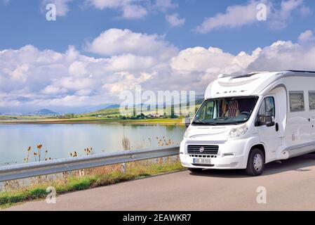 Motor home parked at a street with view to a barrage lake Stock Photo