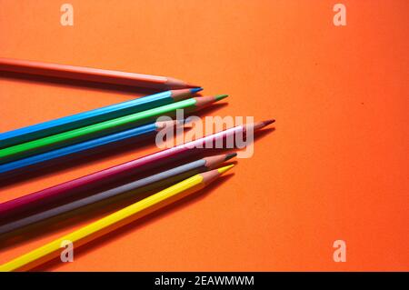 A group of messy colored paints on an orange surface and with copy space Stock Photo