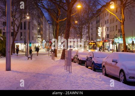 Outdoor night view on the sidewalk beside row of parking car which covered by thick layer of snow in Düsseldorf, Germany. Stock Photo